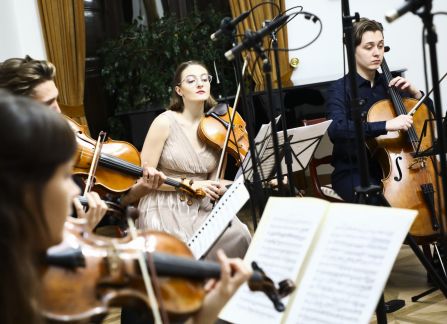 fotografia. Koncert we wnętrzu Willi Decjusza. Muzycy grają na skrzypcach i wiolonczeli.